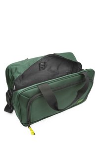 Bolsa de tela verde con cierre de cremallera, dobles asas negras y un interior con estampado. Presenta un tirador de cremallera amarillo para mayor accesibilidad.