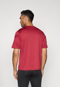 Rode sportieve shirt met korte mouwen, gemaakt van gladde, lichte stof. Heeft een ronde halslijn en accenten op de schouderpanele.