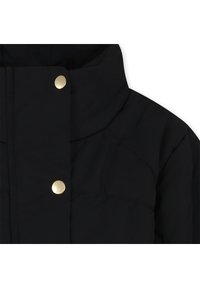 Svart pufferjacka med hög krage, guldknappar, texturerad tyg och quiltad design.