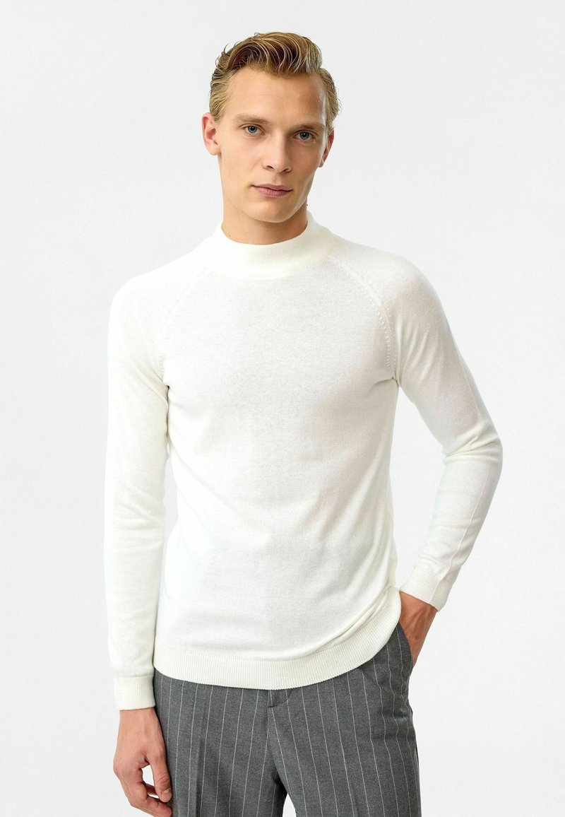 Witte, lange mouwen pullover trui met een hoge halslijn, geribde manchet en een aansluitend ontwerp, gemaakt van een zachte, lichte stof.
