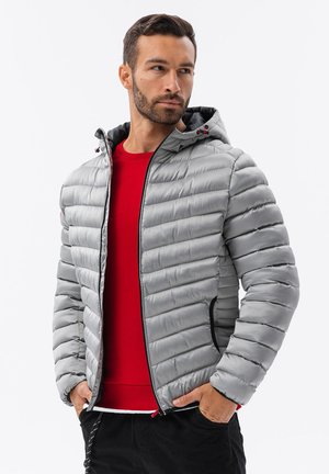 Grijze pufferjack met capuchon, voorzien van horizontale stiksels, elastische manchetten, ritszakken en rode accenten op de ritsen en voering.