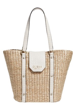 Beige vævet tote-taske med hvide stropper og klap i kunstlæder, med guldfarvet "GUESS EST 1981" logo på forklappen.