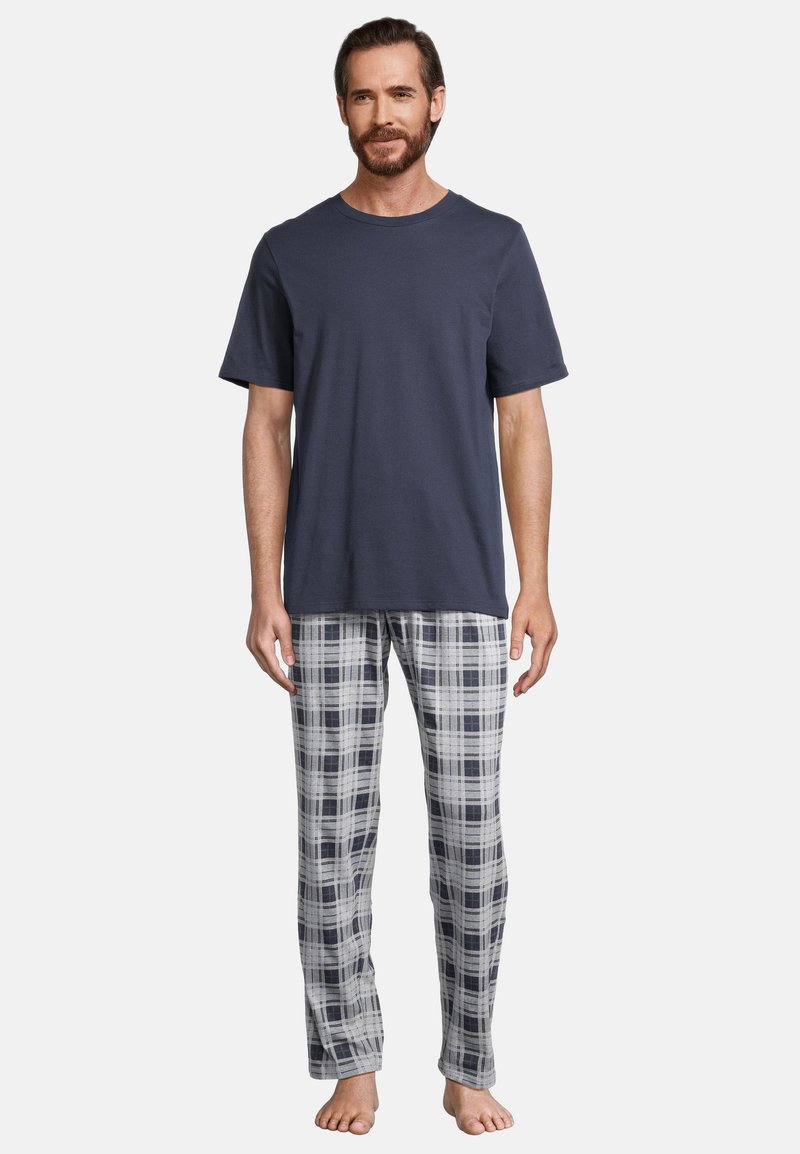 T-shirt di cotone navy a maniche corte, abbinato a pantaloni in flanella grigia e bianca a quadri, caratterizzati da una texture morbida e un design dritto.