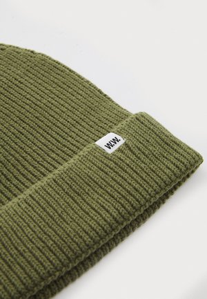 Gorro de punto verde con textura acanalada y puño doblado, que presenta una pequeña etiqueta blanca con "WWW." en el costado.