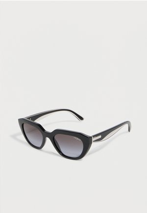 Czarne okulary przeciwsłoneczne w kształcie kocich oczu z gradientowymi szarymi szkłami i cienkimi zausznikami, przedstawione na jednolitym białym tle.