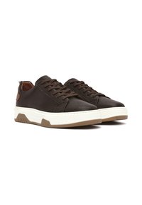 Zapatillas de cuero marrón texturizado con cordones marrones, una entresuela blanca y una suela de goma beige. Presentan acentos en el talón en contraste marrón.