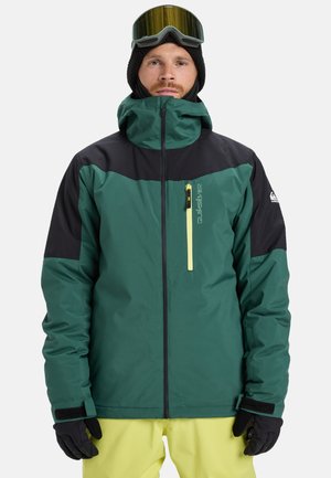 Grün-schwarze Skijacke mit hohem Kragen, durchgehendem Reißverschluss und einer gelben Reißverschlusstasche. Ausgestattet mit langen Ärmeln und elastischen Bündchen.