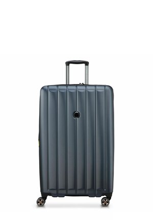 Maleta rígida de color gris oscuro, con surcos verticales, un mango telescópico y cuatro ruedas giratorias para mayor movilidad.
