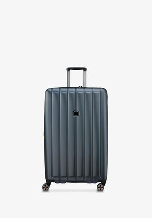 Maleta rígida de color gris oscuro, con surcos verticales, un mango telescópico y cuatro ruedas giratorias para mayor movilidad.