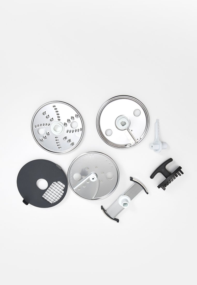 Ensemble d'attachments pour robot culinaire comprenant des disques métalliques argentés, une base en plastique noir avec râpe et une lame grise, disposés sur un fond blanc.