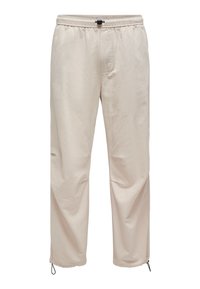 Jasnobeżowe spodnie wykonane z gładkiego materiału. Posiadają elastyczną talię z sznurkiem, boczne kieszenie oraz regulowane mankiety.