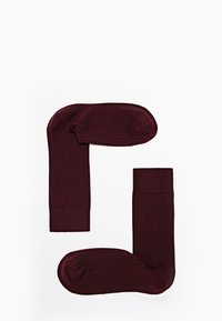 Bordeaux-ribbeede sokker med en tekstureret finish, der har en forstærket tå og manchet, vist i et parlayout mod en hvid baggrund.