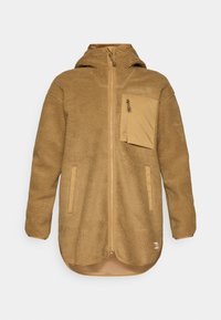 Beige fleecejakke med glidelås foran, hette og brystlomme. Har teksturert stoff og kontrasterende kantbånd rundt kantene.