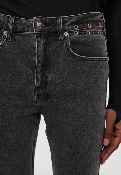 Jeans in denim nero con un classico design a cinque tasche, accessori in metallo e cuciture a contrasto; include occhielli decorativi sulla vita.