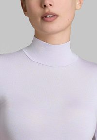 Top a collo alto e maniche lunghe in morbido tessuto di color viola chiaro. Design aderente con una texture liscia e dettagli di cucitura minimali.