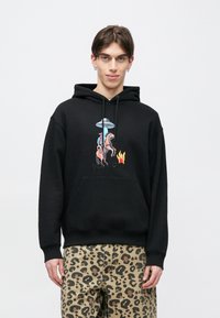 Μαύρο φούτερ με κουκούλα και μπροστινό γραφικό που απεικονίζει έναν άνδρα πάνω σε άλογο κάτω από ένα εξωγήινο UFO και φλόγες. Διαθέτει τσέπη καγκουρό και κουκούλα με κορδόνι.