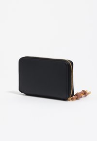 Czarny prostokątny portfel zapinany na zamek z złotym zamkiem i brązowym sznurkiem z węzłem na białym tle.