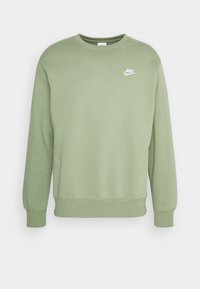 Sudadera Nike verde oliva con cuello redondo, mangas largas y puños acanalados. Presenta un pequeño logo blanco en el lado izquierdo del pecho.
