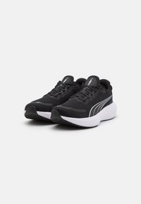 Zapatillas deportivas negras con parte superior de malla, acentos blancos, collar acolchado y suela de goma texturizada, diseñadas para comodidad y soporte.