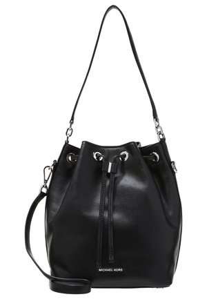Sac seau en cuir noir avec fermeture à cordon, œillets en argent, bandoulière réglable et logo "Michael Kors" à l'avant.