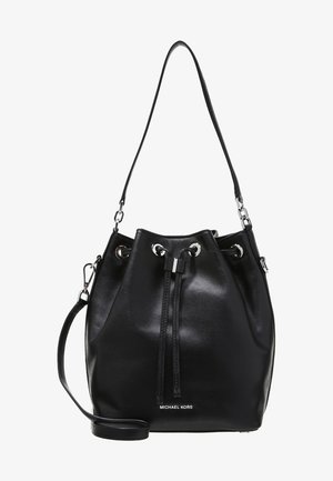 Zwarte leren bucketbag met trekkoordsluiting, zilveren oogjes, verstelbare schouderriem en "Michael Kors"-logo aan de voorkant.