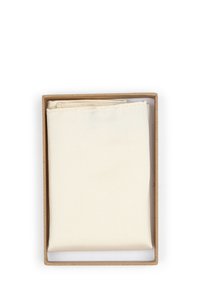 Natuurlijke stoffen vierkant in crème kleur, gevouwen en geplaatst in een bruine kartonnen doos met een gestructureerd oppervlak en schone randen.