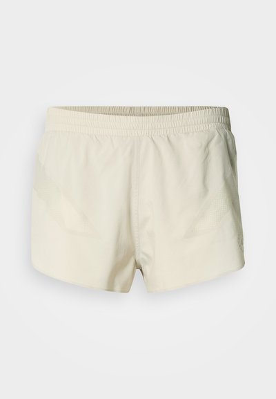 Αθλητικές σορτς σε ανοιχτό μπεζ χρώμα με ελαστική μέση, που διαθέτουν υφή στα πλαϊνά και λεία επιφάνεια υφάσματος.