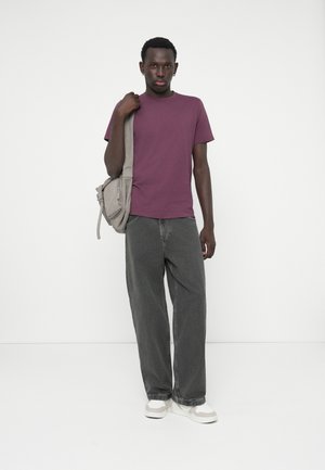 Korte mouwen maroon t-shirt, losse grijze jeans, grijze schoudertas en witte sneakers met grijze accenten. Eenvoudig ontwerp en casual stijl.