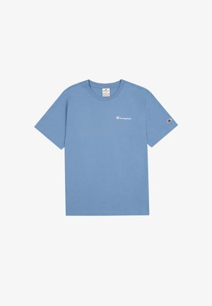T-shirt di cotone azzurro chiaro con maniche corte, caratterizzata da un piccolo logo rosso e bianco sul lato sinistro del petto e una toppa con logo sulla manica destra.