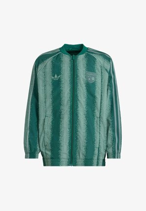 Zielona kurtka z zamkiem, wzór w pionowe paski i teksturowane akcenty. Posiada logo Adidas oraz badge Minecraft na klatce piersiowej.