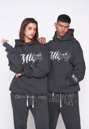 Mørkegrå hættetrøjer med stort hvidt "Multiply" logo. Har oversized pasform, ribbede manchetter og kængurulommer. Sammen med matchende sweatpants.