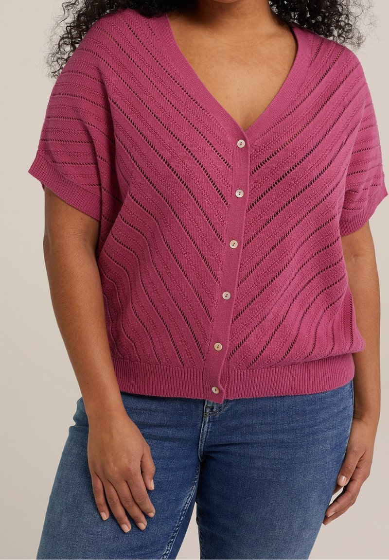 V-ringad stickad cardigan i mörkrosa, korta ärmar, med ett vågmönster och sju knappstängning framtill. Mjuk textur.