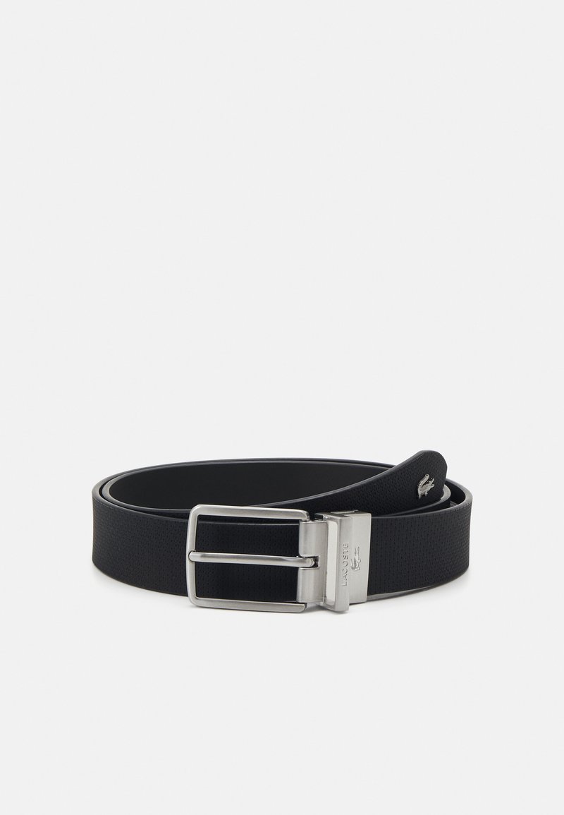 Sorte syntetisk bælte med en tekstureret finish, der har en sølvmetalspænde og prægede logo. Bæltet er enkeltlag, fladt og elegant.