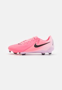 Nike focicipő élénk rózsaszínben, textúrázott felsőrésszel, fekete részletekkel és fekete tüskeakkorokkal. Jellemzője a szoros fűzős kivitel és a logó részlet.