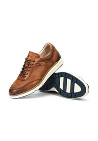 Zapatos de cuero marrón con diseño perforado, que presentan una suela de color crema y cierre de cordones en la parte frontal. Acentos texturizados en los laterales y en la parte trasera.