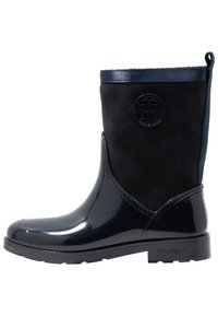 Mustat vedenpitävät saappaat kiiltävällä pinnalla, mokkanahkaisella päällisellä ja kuvioidulla kumipohjalla. Varustettu kohotetulla logolla ja vetolenkillä helpottamaan pukemista.