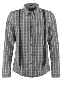 Chemise à manches longues à carreaux gris et noirs avec des bretelles noires attachées à l'avant.