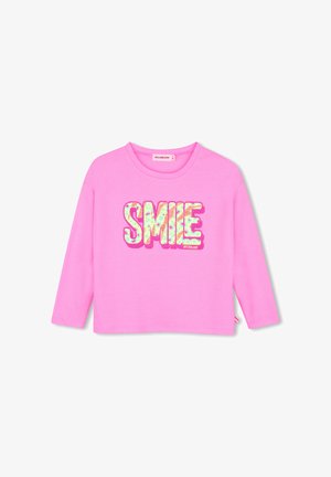 Chemise rose vif à manches longues avec col rond et le mot "SMILE" en grandes lettres colorées et décorées sur le devant.