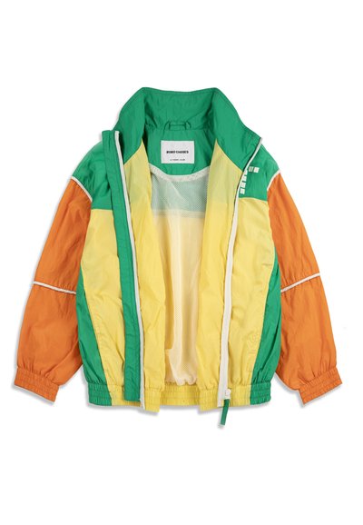 Veste coupe-vent légère pour enfants en vert, jaune et orange avec poignets élastiques, doublure en mesh et fermeture éclair avant, ouverte et étalée à plat.