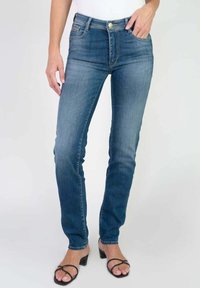 Jeans de mezclilla de tiro alto en azul claro, con un diseño ajustado, mínimo desgaste y estilo clásico de cinco bolsillos.