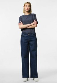 Dark blue wide-leg jeans with a high waist, made from denim fabric, paired with a gray short-sleeve t-shirt. White shoes complete the outfit.