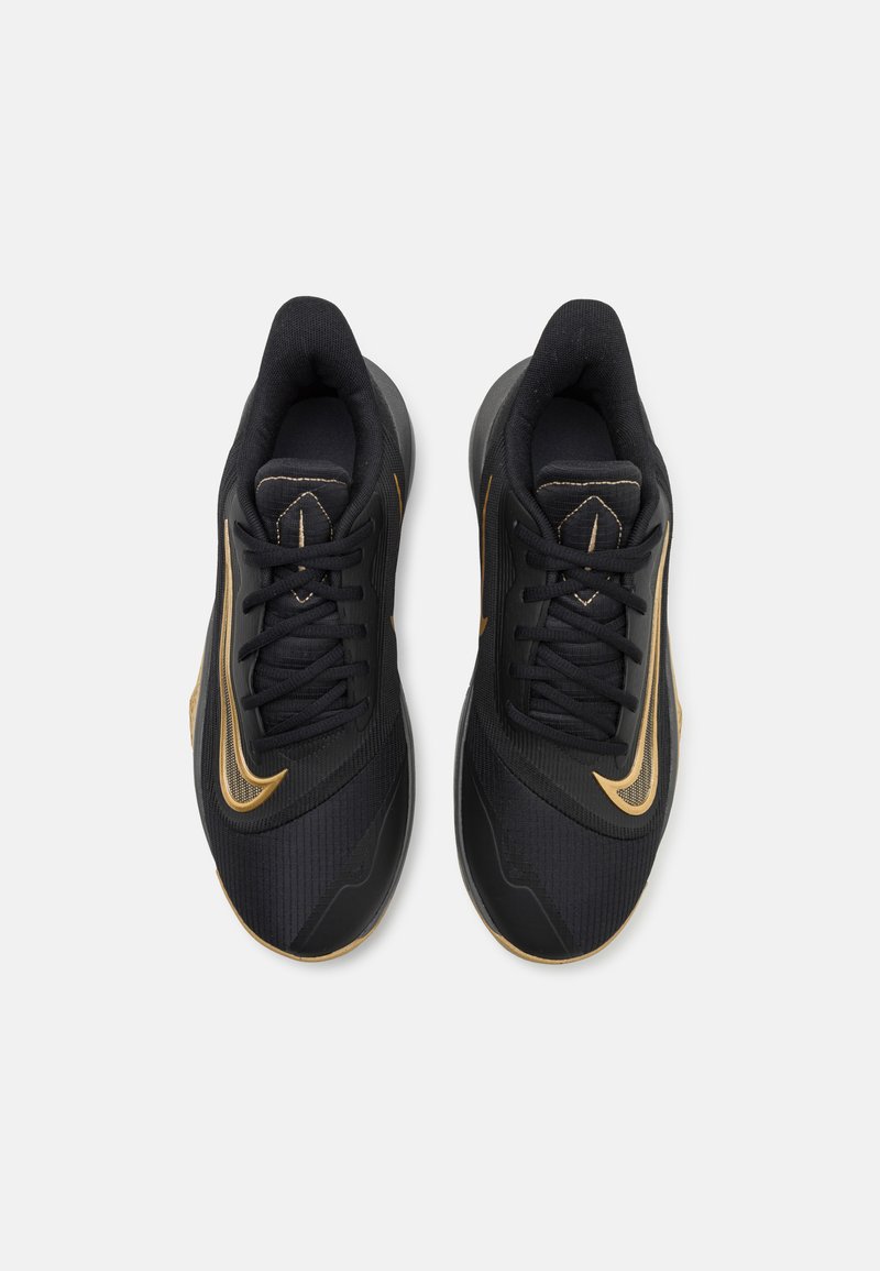 Zapatillas deportivas negras con detalles en dorado, parte superior de tela texturizada y suela acolchada. Presenta un cierre con cordones en la parte delantera y un detalle del logo en el lateral.