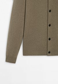 Cardigan à manches longues vert olive avec boutons noirs, poignets et ceinture côtelés, présenté sur un fond blanc.