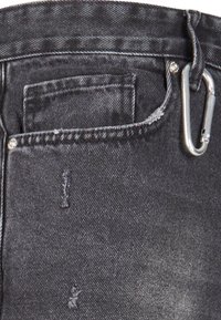Jean en denim noir avec une taille standard, des passants de ceinture et une poche avant avec un petit détail de couture visible. Comprend un mousqueton en argent.