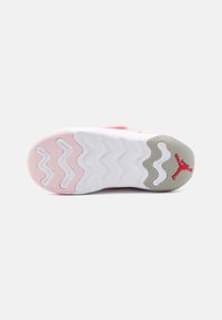 Hvit sneakersåle med rosa og grå aksenter, preget av bølgemønstre og en rød Jordan-logo. Teksturert overflate for grep og stabilitet.