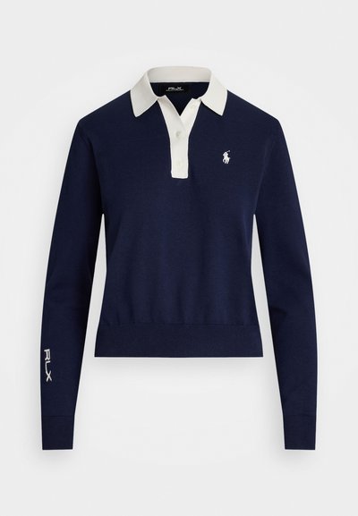 Polo en tricot bleu marine à manches longues avec un col blanc, comportant un petit logo sur la poitrine et "RLX" brodé sur la manche.