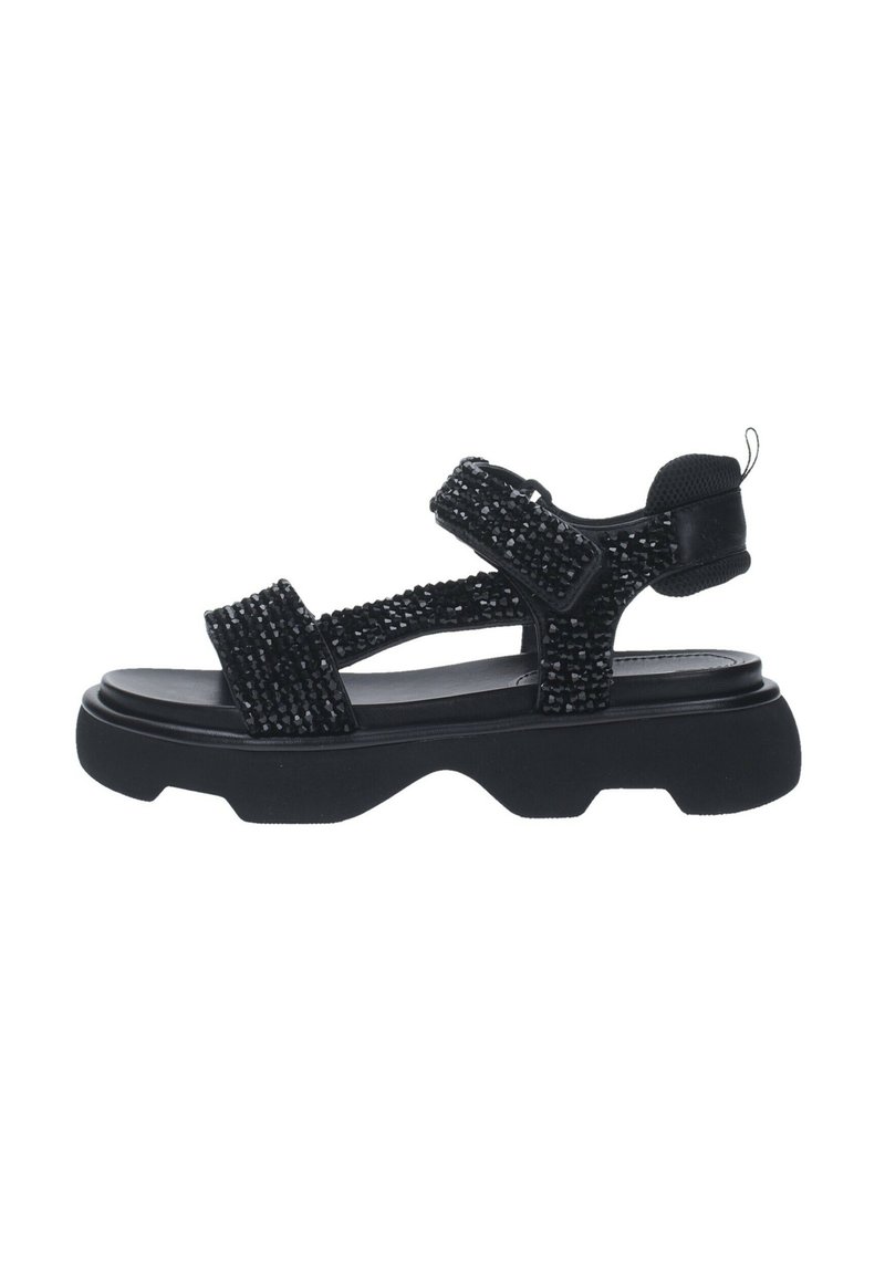 Sandalia negra con correas texturizadas y cierres ajustables, suela gruesa y acabado suave. Diseño adecuado para uso casual.