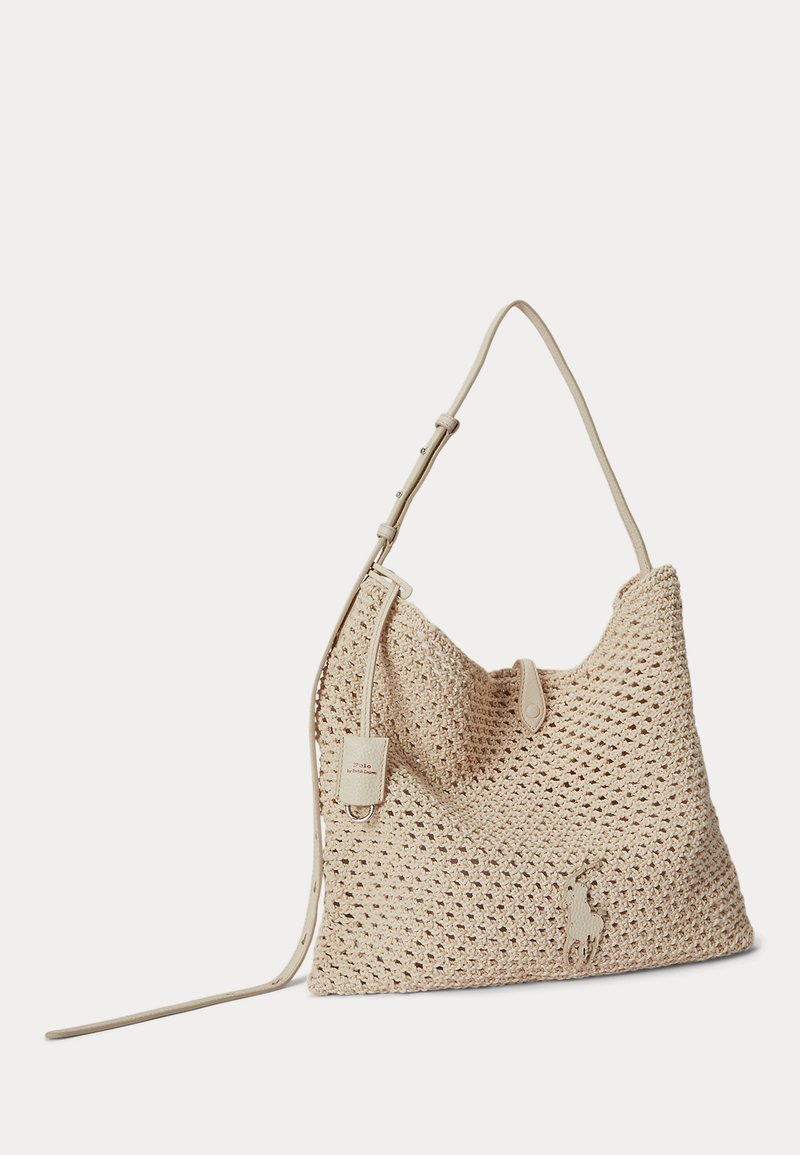Sac d'épaule beige tissé avec bandoulière réglable, petite fermeture à rabat et écusson logo Polo sur tissu texturé.