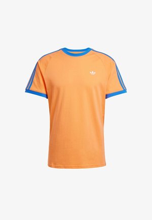 Maglietta in cotone arancione con colletto e polsini blu a coste. Presenta un logo bianco sul petto e strisce blu sulle spalle.