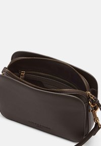 Borsa a tracolla in pelle marrone con zip dorate, doppie tasche e superficie testurizzata. Caratterizzata da una tracolla regolabile e un logo impresso.
